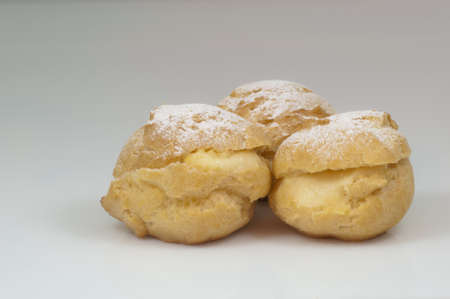 three cream puffs with sugar and white background - DSC0777の写真素材