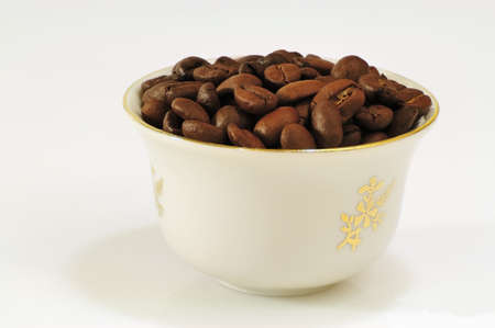 white ceramic cup filled with roasted coffee grains - DSC0424の写真素材