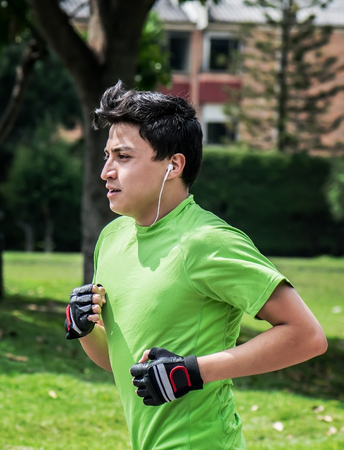 Young man at a local park jogging near home, vertical picの写真素材