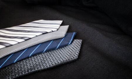 Some ties of cold colors over black clothの写真素材