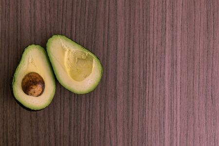 A small ripe avocado split into two pieces