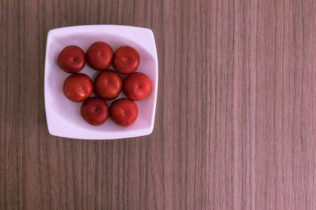 Small dish with some fresh red plumsの写真素材