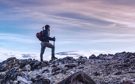 Profile picture of mountaineer prepared with his gear on top of the mountain contemplating the beautiful colors of the sky at sunrise, taken in the snowy of Tolima Colombiaの写真素材