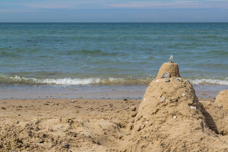Sand castle on beach with ocean in backgroundの写真素材