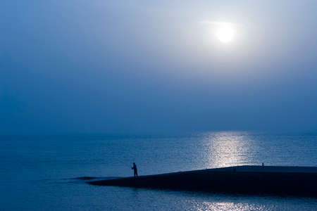 Man fishing by the seaside の写真素材