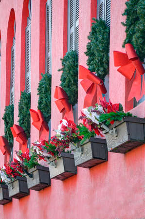 Wreaths and red ribbons decorate windows during the Christmas holiday season.の写真素材