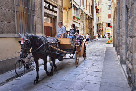 Florence, Italy - September 6, 2021: Horse drawn carriage with tourists ride through Florence, Italy.  Editorial.のeditorial素材