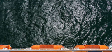 View from the top of a sailing cruise ship. Life boats sticking out. Cruising concept.の写真素材