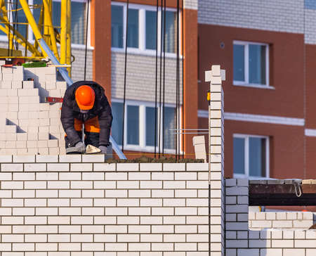 View of Construction Worker Laying Bricks. Construction Site Concept.のeditorial素材
