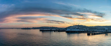 Port of Dover, England - June 24, 2020: Panoramic wide angle shot of Dover Port with P&O, DFDS ferry boats, cruise ship docked at sunset. Beautiful orange, red, blue sky and hills in the background.のeditorial素材