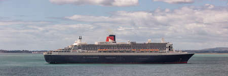 Weymouth Bay, United Kingdom - July 6, 2020: Beautiful panoramic shot of Cunard cruise ship Queen Mary 2 anchored in Weymouth Bay.のeditorial素材