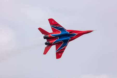 Barnaul, Russia - September 19, 2020: A close-up shot of Strizhi MiG-29 fighter jet performing stunts during an aeroshow. Blue cloudy sky as a background.のeditorial素材