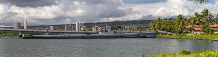 Pearl Harbor, Honolulu, Hawaii, USA - September 23, 2018: Panoramic shot of USS Bowfin submarine docked next to the USS Arizona Memorial Visitor Center. Honolulu and cloudy sky as a background.のeditorial素材