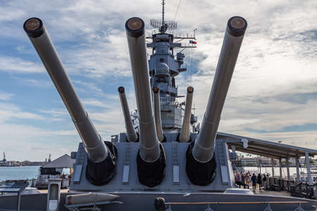 Pearl Harbor, Hawaii, USA - September 24, 2018: Huge cannons of USS Missouri docked in Pearl Harbor. Blue sky with white clouds as a background.のeditorial素材