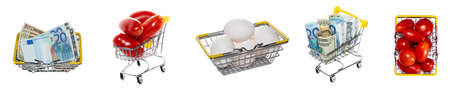 Fresh white eggs, ripe red tomatoes, mixed euro and dollar bills in shopping baskets, carts. Isolated on white background. High angle, top views. Tomato, eggs trading, shopping concepts. Banner size.の写真素材