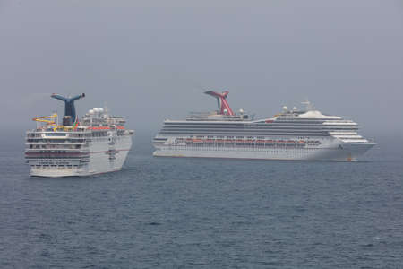 The Caribbean Sea - May 26, 2020: Aerial panoramic shot of Carnival Elation and Carnival Sunrise anchored at sea in the fog. Gray foggy sky in the background.のeditorial素材