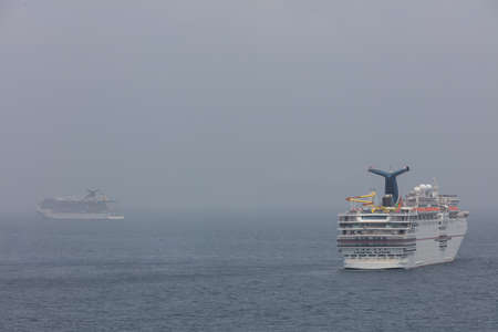 The Caribbean Sea - May 26, 2020: Aerial panoramic shot of Carnival Elation and Carnival Legend anchored at sea in the fog. Gray foggy sky in the background.のeditorial素材