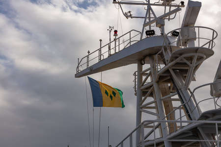 Low angle shot of the flag of Saint Vincent and the Grenadines waving in the wind on the ship's...