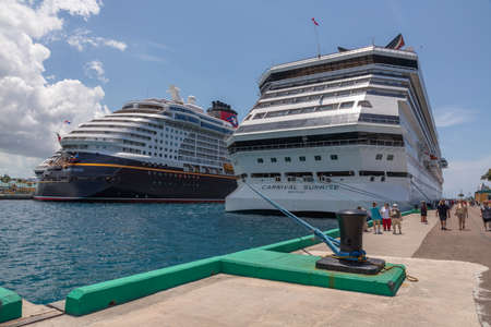 Nassau, Bahamas - May 14, 2019: Carnival Sunrise cruise ship docked at Prince George Wharf. Pier with mooring pool in the foreground. Blue cloudy sky and Disney Dream in the background.のeditorial素材