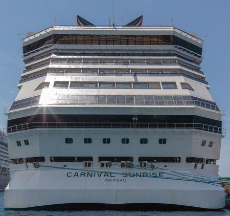 Nassau, Bahamas - May 14, 2019: Carnival Sunrise cruise ship docked at Prince George Wharf. Blue mooring lines leading to the pier. Tip of the funnel showing on top. Blue sky in the background.のeditorial素材