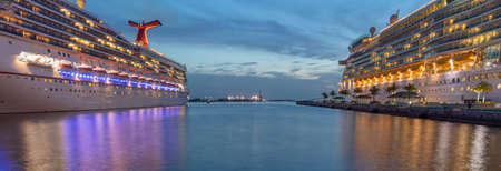 Nassau, Bahamas - June 22, 2019: Beautiful panoramic shot of Carnival Liberty, Mariner of the Seas cruise ships in Prince George Wharf at sunset. Blue hour. Reflections in the water in the foreground.のeditorial素材