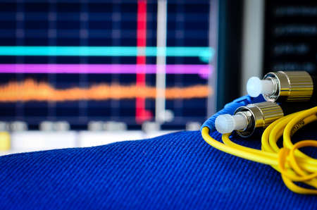 Fibre optic cable with spectrum analyser in the backgroundの写真素材