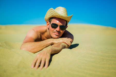 sexy young man at a  dune beachの写真素材