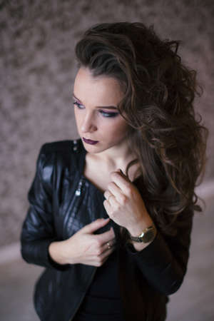 Punk rock style or halloween make-up. Fashion woman model face with bright glamour makeup. Perfect skin, black gloss eyeshadows on eyes and dark brown glossy lips visage.の写真素材