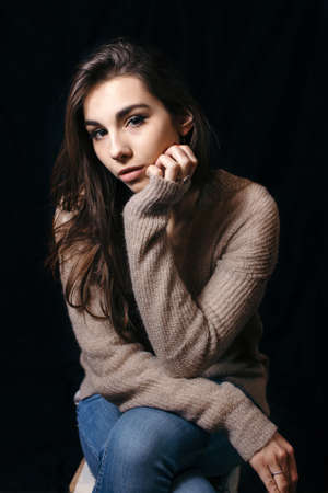 Beautiful brunette woman on black background. Close up of an attractive girl of European appearance.の写真素材