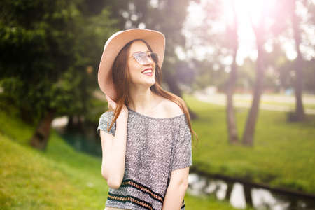 Fashion lifestyle portrait of young happy pretty woman laughing and having fun in the park at nice sunny summer day, stylish vintage outfit,bright fresh colors.の写真素材