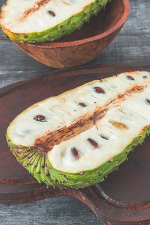 delicious green soursop cut in half in top of a gray surfaceの写真素材