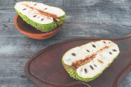 delicious green soursop cut in half in top of a gray surfaceの写真素材