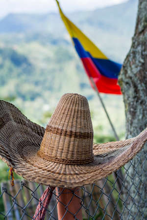traditional colombian hut and flag in a mountainous landscapeの写真素材