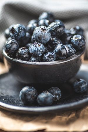 Fresh blueberries in bowl on rustic wooden background. Healthy food concept.の写真素材