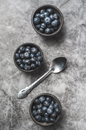 Fresh blueberries in bowls on gray background, top view, copy spaceの写真素材