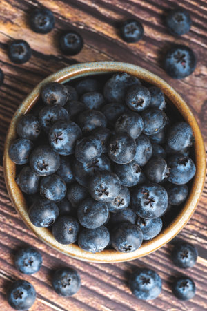 Blueberries in a bowl on a wooden background. Toned.の写真素材