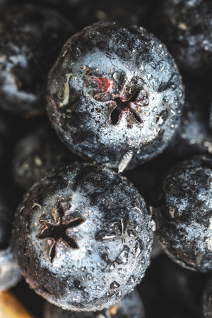 Freshly picked blueberries in a wooden bowl close-up.の写真素材