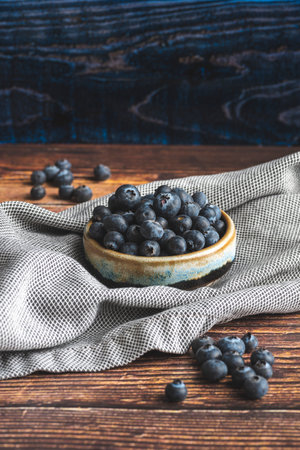 Fresh blueberries in a bowl on a wooden table, rustic styleの写真素材