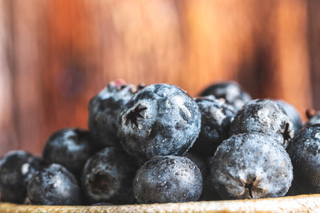 Fresh blueberries in a bowl on rustic wooden background, close upの写真素材