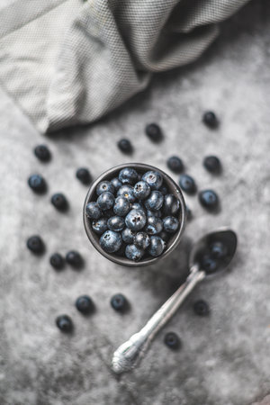 Blueberries in a bowl on a gray background. top view.の写真素材