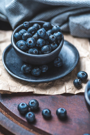 Blueberries in a bowl on a wooden table. Toned.の写真素材