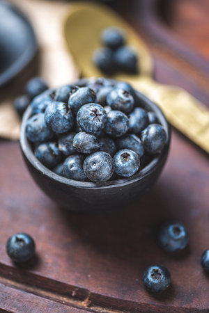 Blueberries in a bowl on a wooden background. Select focus.の写真素材