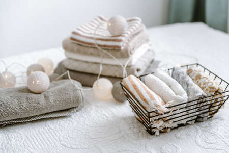 Laundry, towels folded and rolled in baskets in bedroom. Concept of tidiness, minimalism lifestyle and japanese folding system. Organizing wardrobe, stuff in boxesの写真素材