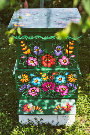 Zalipie, Poland, Jun 2020: Traditional, old, wooden beehive decorated with flower pattern and floral...