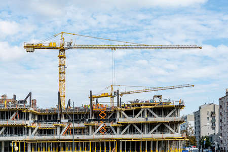 Warsaw, September 2020: Construction site - office building under construction with scaffolding and cranes on sky backgroundのeditorial素材