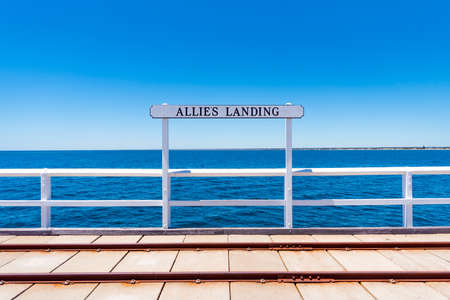 Allies Landing sign on Busselton Jetty with train tracks and Indian Ocean waters in the background, Western Australiaの写真素材