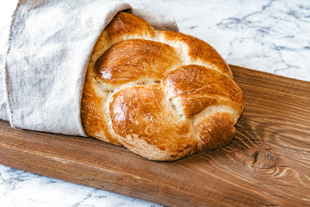 Homemade Jewish traditional challah bread on rustic wooden cutting board