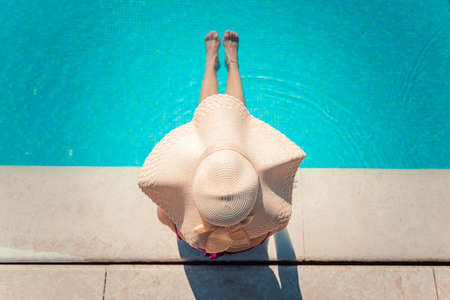 Unrecognizable young woman in big hat relaxing in the pool at the spa resort. Relaxing conceptの写真素材