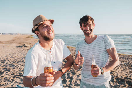 Two friends hug each other at the sunset on the beach. Friendship and love conceptの写真素材