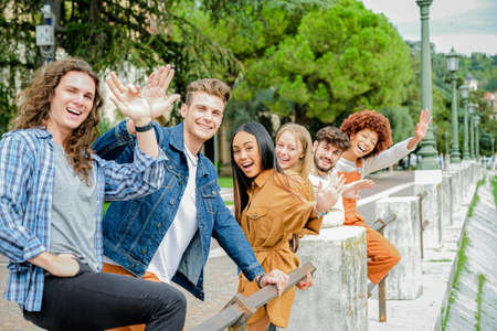 Portrait of happy college friends smiling and greeting looking in camera - Beautiful cheerful multiethnic friends in the city - Friendship conceptの写真素材